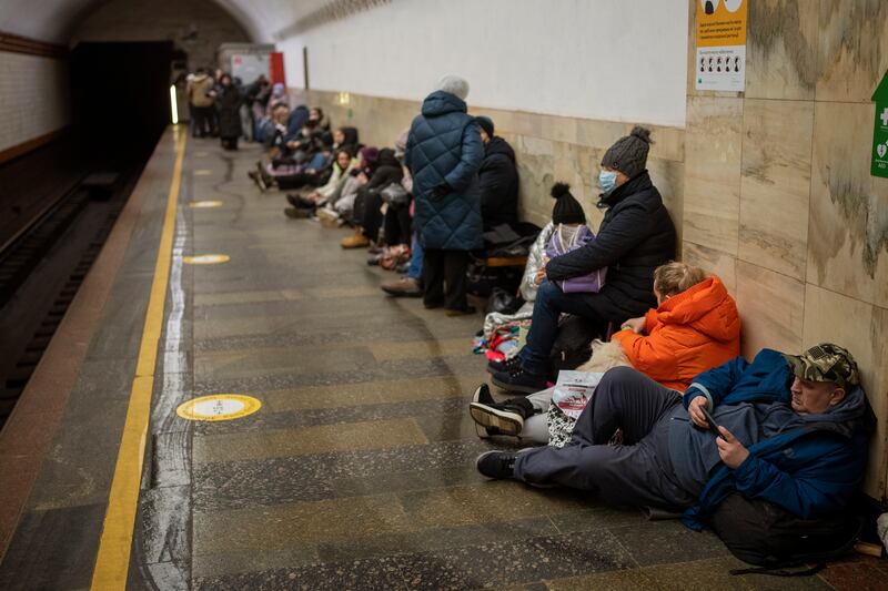 People lie in a Kyiv subway station, seeking shelter from bombs.