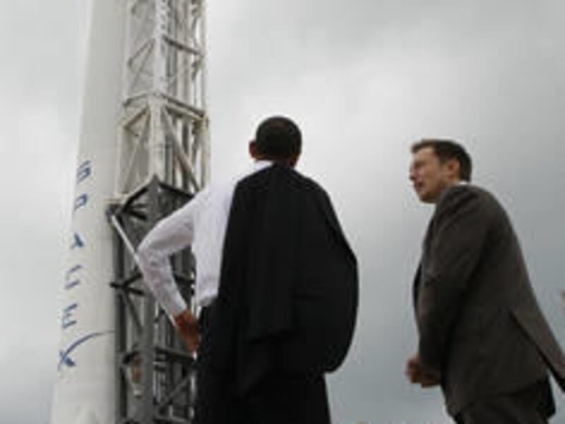 In this April 15, 2010 file photo, President Barack Obama, left, looks at the SpaceX Falcon 9 launch vehicle with Elon Musk, of SpaceX, center, at Kennedy Space Center, Fla.