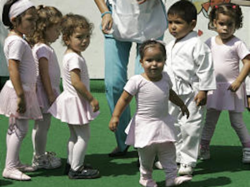 Two-year-old Milagros Cerron, center, plays with other children at her nursery school Thursday in Lima. Milagros was born with "mermaid syndrome."