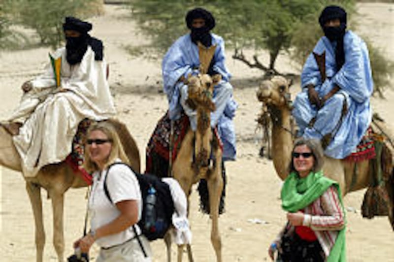 In Timbuktu, Mali, tourists walk past Tuareg nomads who have come into town to sell items of jewelry to visitors. About a third of Mali is covered by desert, and it gets crushingly hot even in the coldest months.