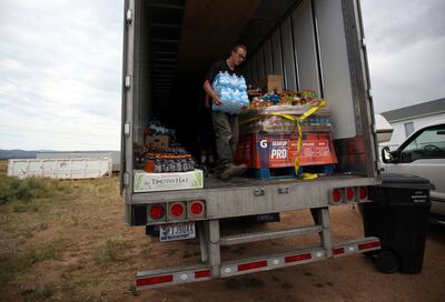 Alex Cook carries donated water for victims of the Dollar Ridge Fire outside an LDS church in Fruitland on Wednesday, July 11, 2018.