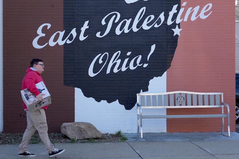 A pedestrian walks by a mural in East Palestine, Ohio.