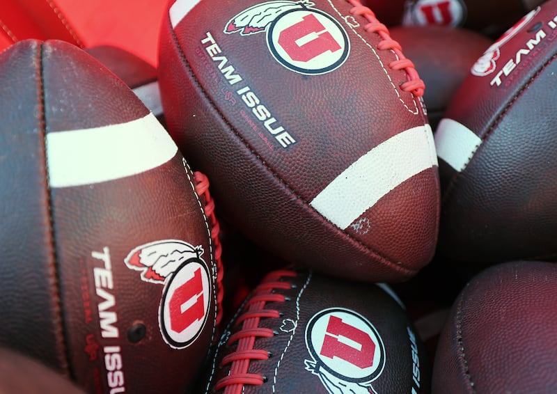 Practice footballs sit in a cart as the Utes and the Trojans prepare to play at Rice-Eccles Stadium in Salt Lake City.