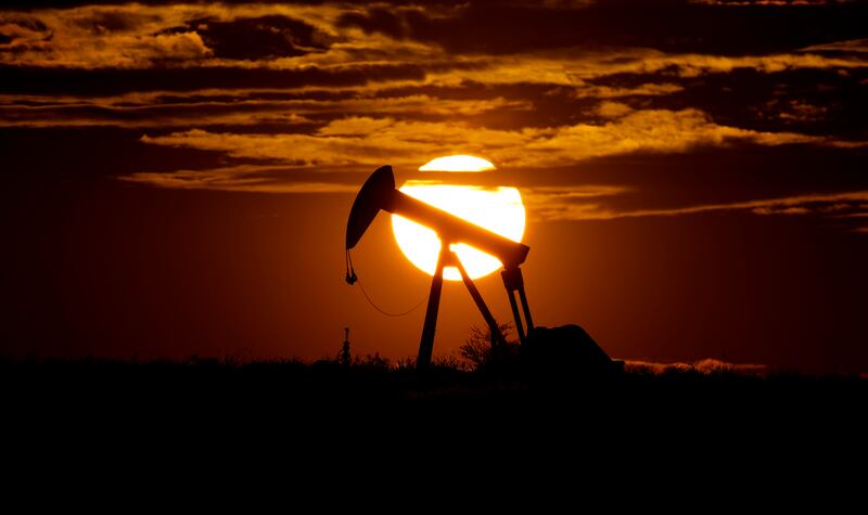 The sun sets behind an idle pump jack near Karnes City, Texas, on April 8, 2020.