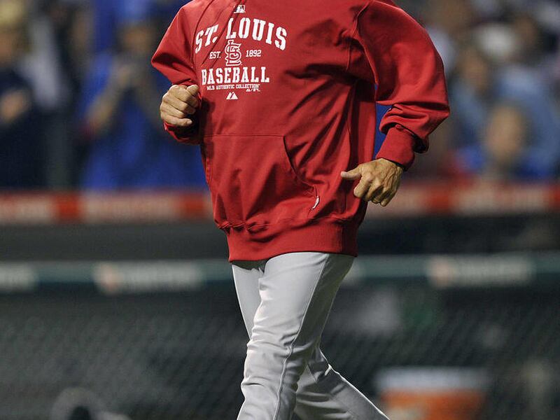 St. Louis Cardinals bench coach Joe Pettini returns to the dugout after talking to an umpire during the sixth inning of the Cardinals' baseball game against the Chicago Cubs on Tuesday, May 10, 2011, in Chicago. Pettini was filling in for manager Tony La