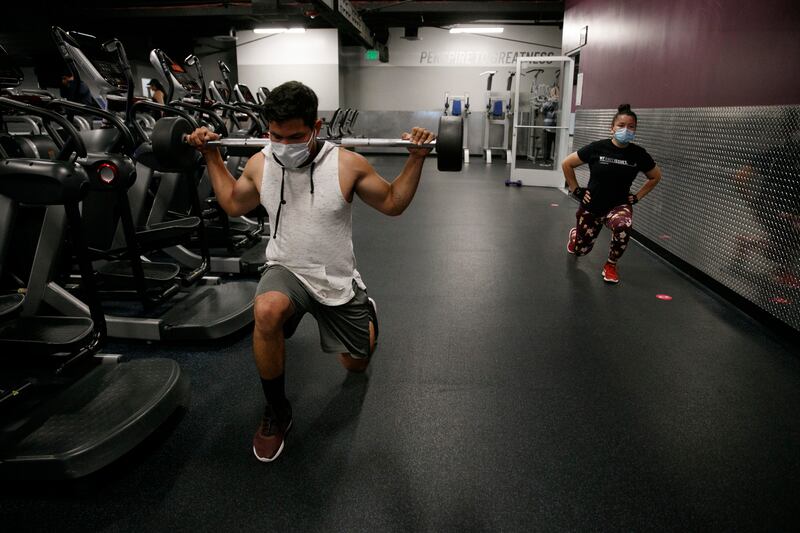 People wear masks while exercising at a gym in Los Angeles.