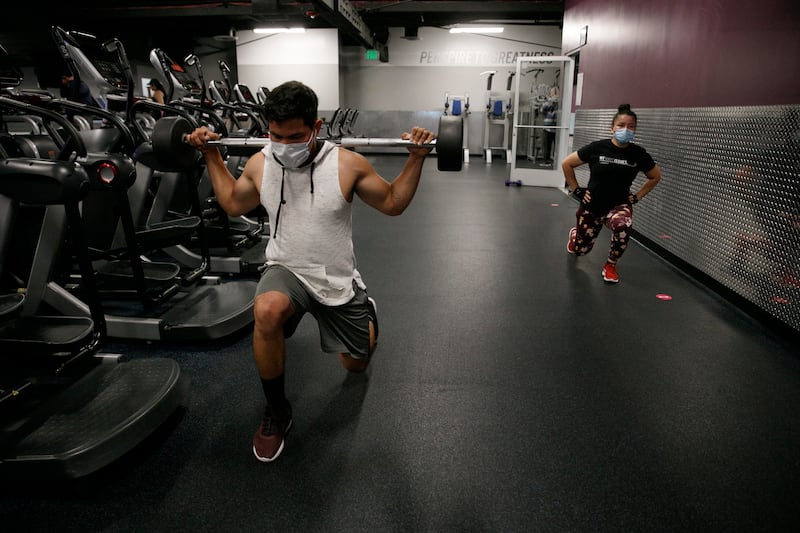 People wear masks while exercising at a gym in Los Angeles.