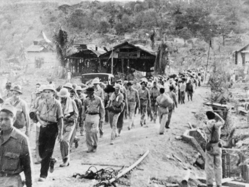 American prisoners of war walk in a line during the 1942 Bataan Death March in the Philippines.