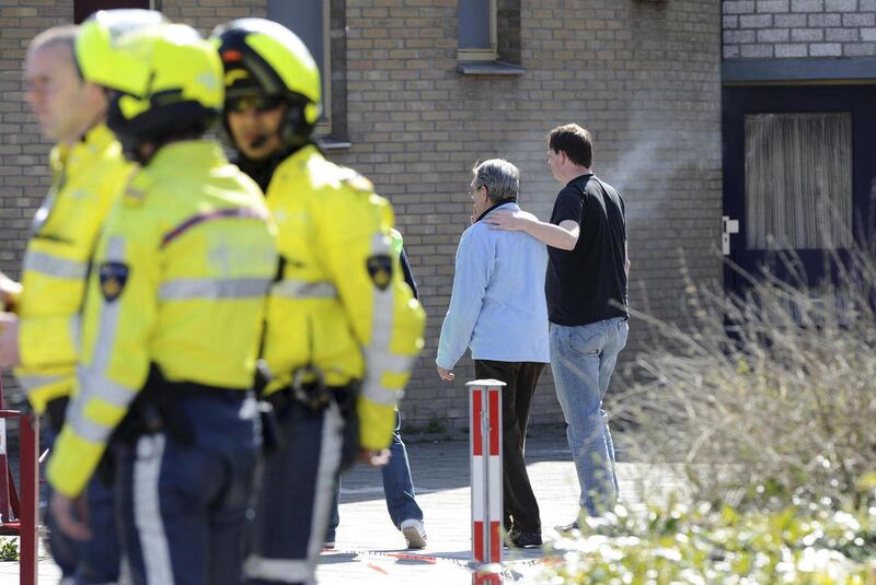 Police officers and neighbors are seen near Ridderhof shopping mall in Alphen aan den Rijn, 15 miles (25 kilometers) southwest of Amsterdam, Netherlands, Saturday, April 9, 2011. A gunman opened fire with an automatic weapon at a crowded shopping mall on