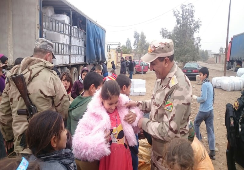 A Yazidi girl chooses a pretty pink coat provided by Latter-day Saint Charities at a refugee camp in Turkey.