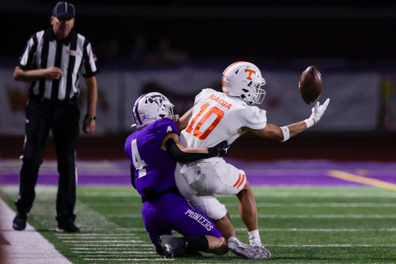 Timpview receiver Tei Nacua (10) catches the ball while being tacked by Lehi’s Lance Olsen (4) in Lehi on Oct. 6, 2022.
