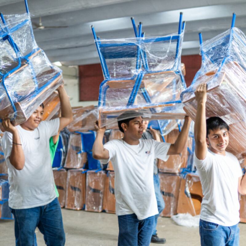 Secondary school students in Escuintla, Guatemala, help load desks onto a moving truck for delivery to a local school on July 25, 2025.