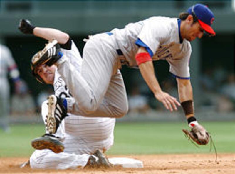 Cubs shortstop Nomar Garciaparra flies over Rockies Jason Jennings after forcing him out at second base.