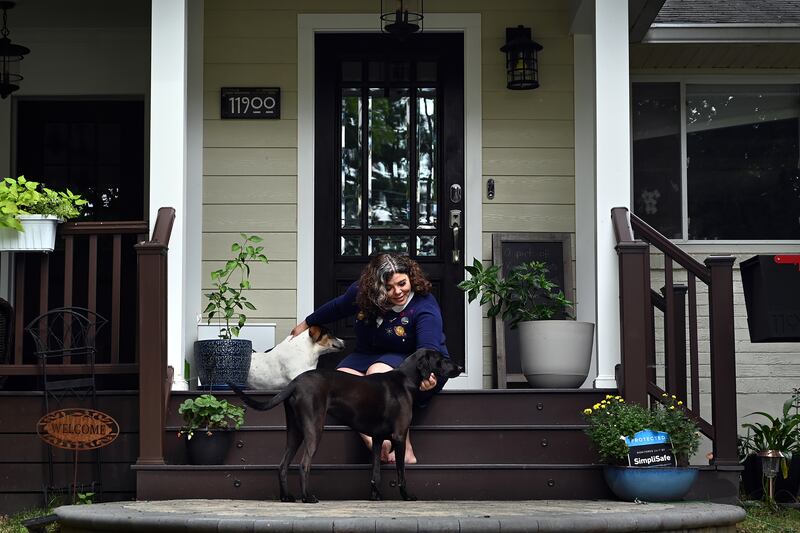 Celeste Headlee sits on her porch in Rockville, Maryland, with two dogs in August 2021.
