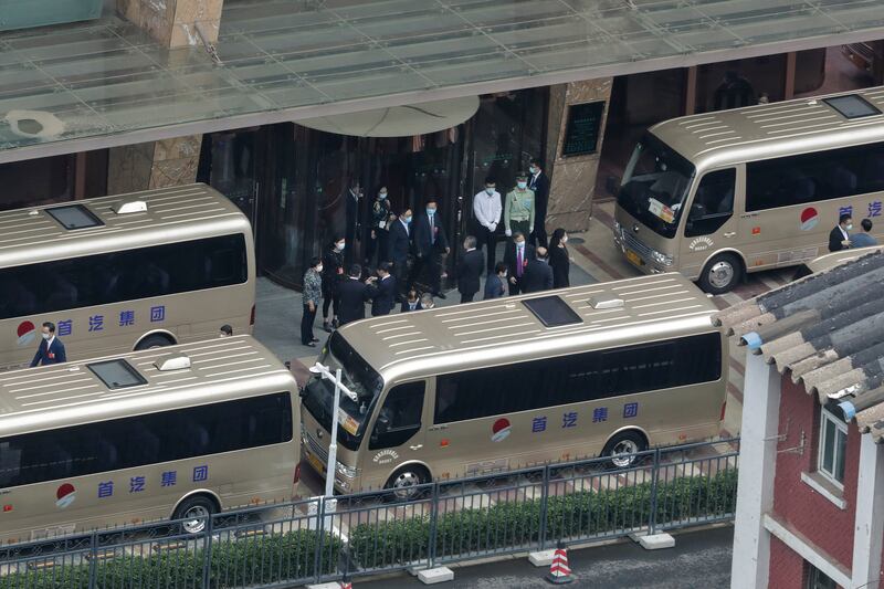 Delegates walk out from a hotel as they prepare to board the buses to head to the Great Hall of the People to attend a plenary session of China’s National People’s Congress (NPC) in Beijing, Monday, May 25, 2020.