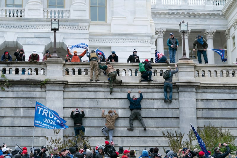 Supporters of President Donald Trump climb the west wall of the the U.S. Capitol in Washington on Jan.6.