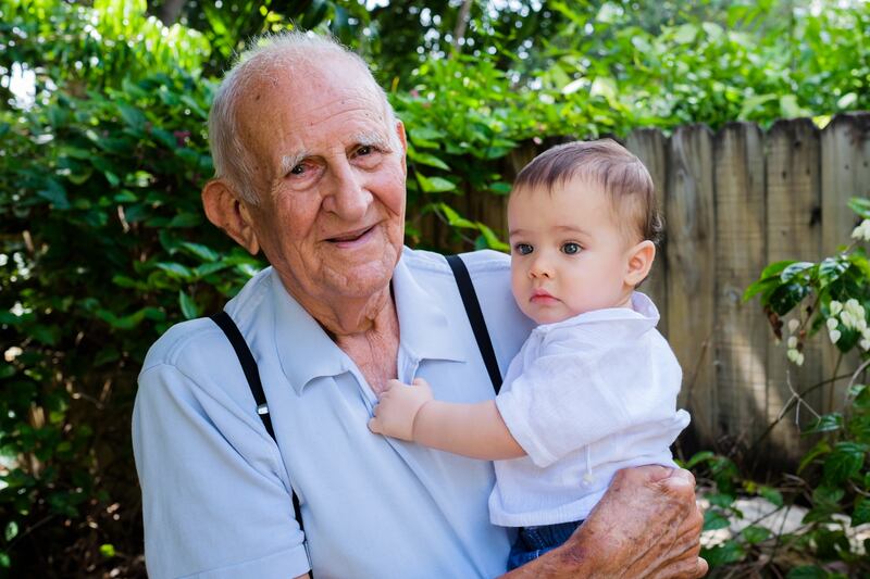 A man holds his grandson. The world’s population is expected to begin to decline this century.