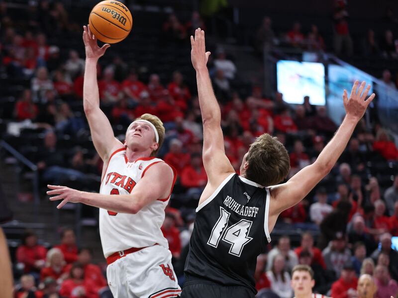 Utah Utes guard Hunter Erickson shoots over Hawaii Warriors forward Harry Rouhliadeff at the Delta Center in Salt Lake City.