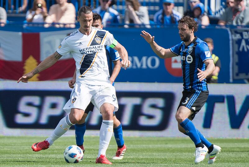 Montreal Impact's Marco Donadel moves in on Los Angeles Galaxy's Zlatan Ibrahimovic, left, during the first half an MLS soccer match in Montreal, Monday, May 21, 2018. (Graham Hughes/The Canadian Press via AP)