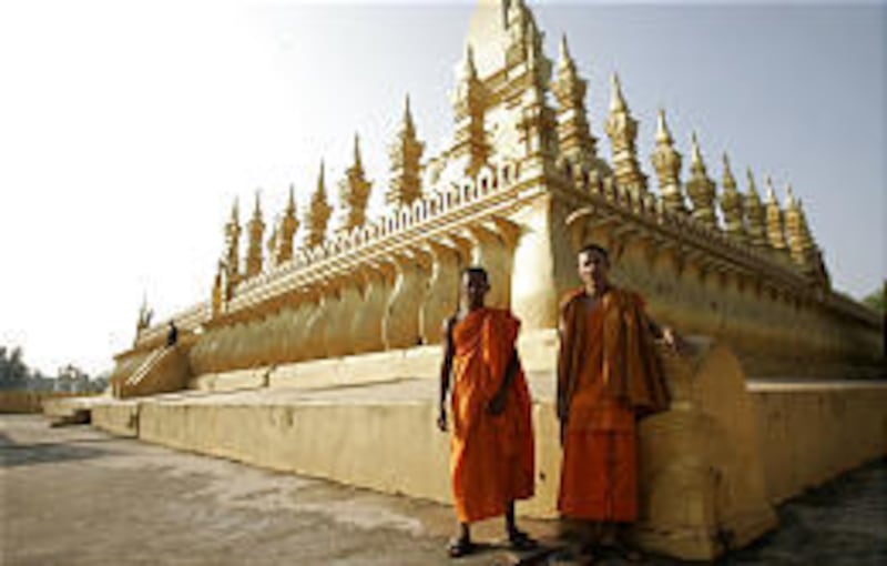 Buddhist monks gather at Pha That Luang in Vientiane, Laos. A common sight in laid-back Vientiane is free-roaming chickens in the city's center.