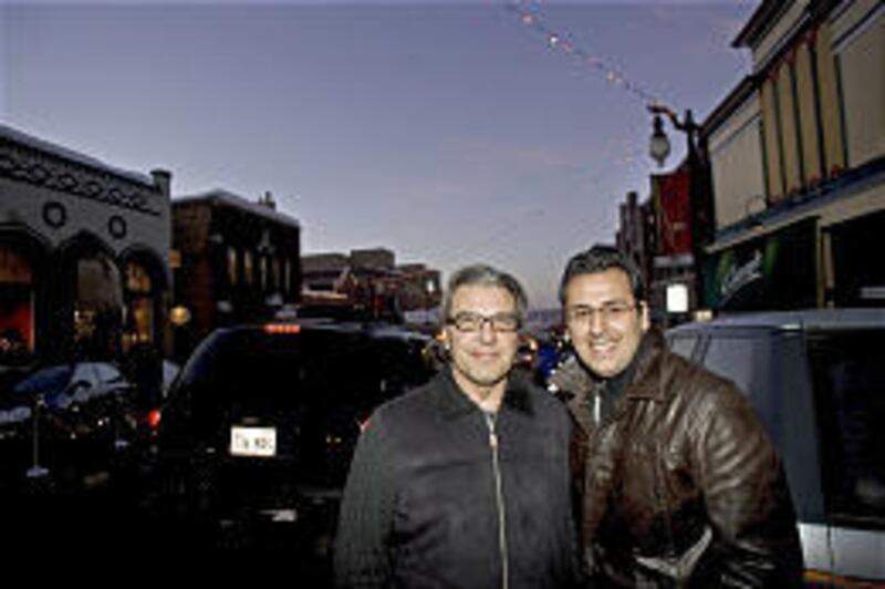 Gerry Frascione, an Italian who lives in Toronto, and Nassir Marrouche of Lebanon soak up the action on Park City's Main Street Friday.