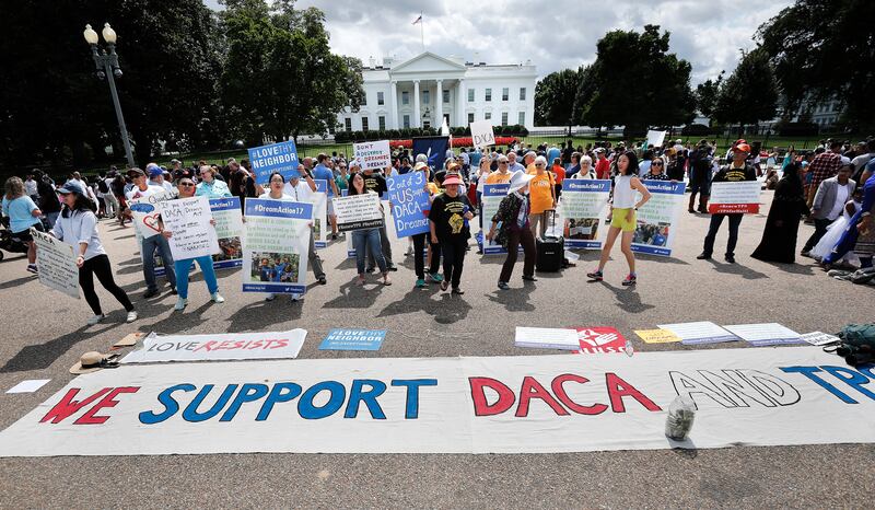 Supporters of Deferred Action for Childhood Arrivals program (DACA), layout a banner as they demonstrate on Pennsylvania Avenue in front of the White House in Washington, Sunday, Sept. 3, 2017. After months of dragging his feet, President Donald Trump wil