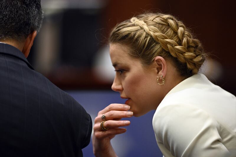 Actress Amber Heard talks to her attorney during the trial at the Fairfax County Circuit Court in Fairfax, Va.