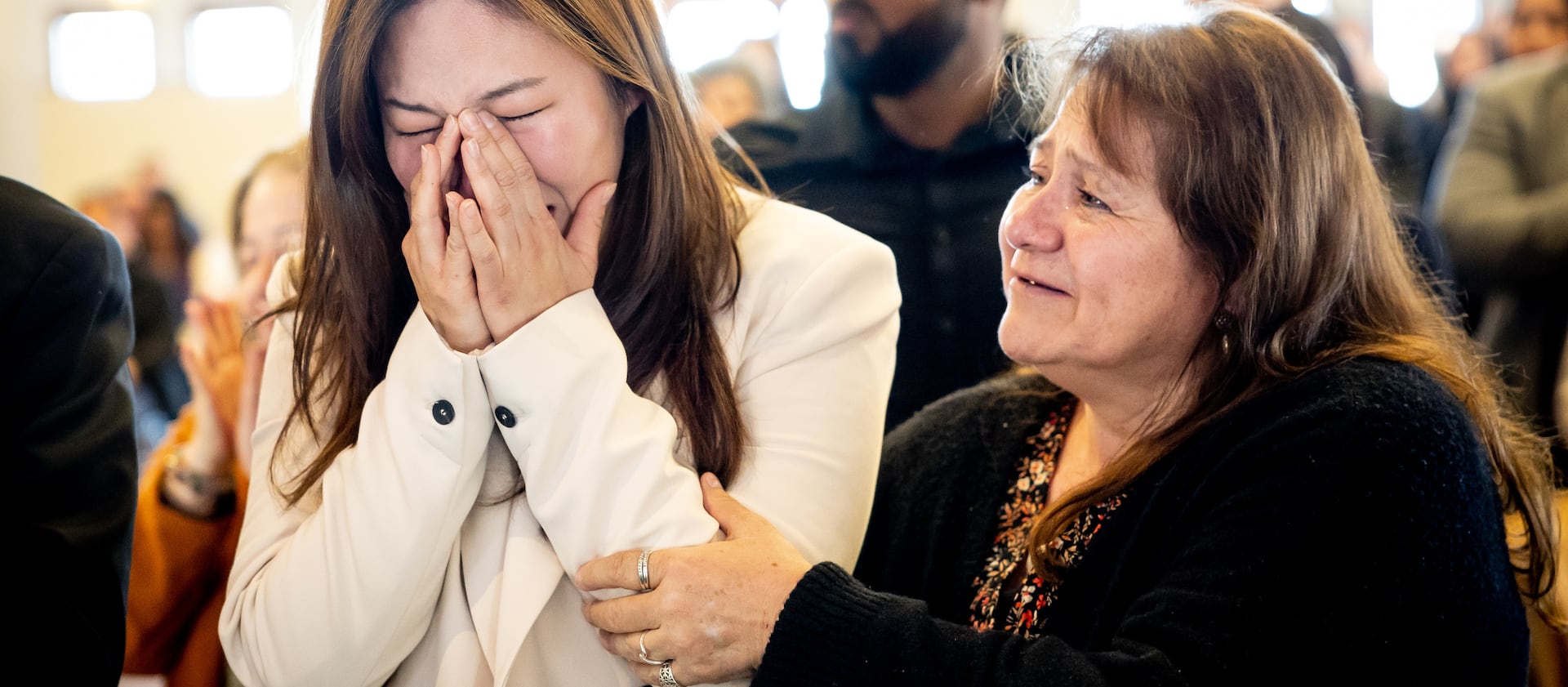 Yeona Bae, from South Korea, bursts into tears and is comforted by Viviana Vicencio, from Chile, after they became U.S. citizens