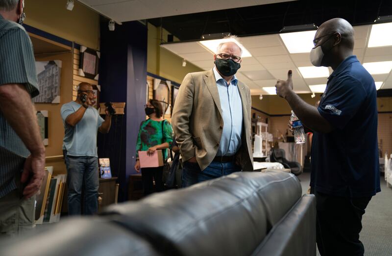 Gov. Tim Walz, center, listens at Elsa’s House of Sleep in St. Paul, Minn., Monday, June 8, 2020, as its owner Tetra Constantino described how he and his employees stayed up all night defending the business from looters.