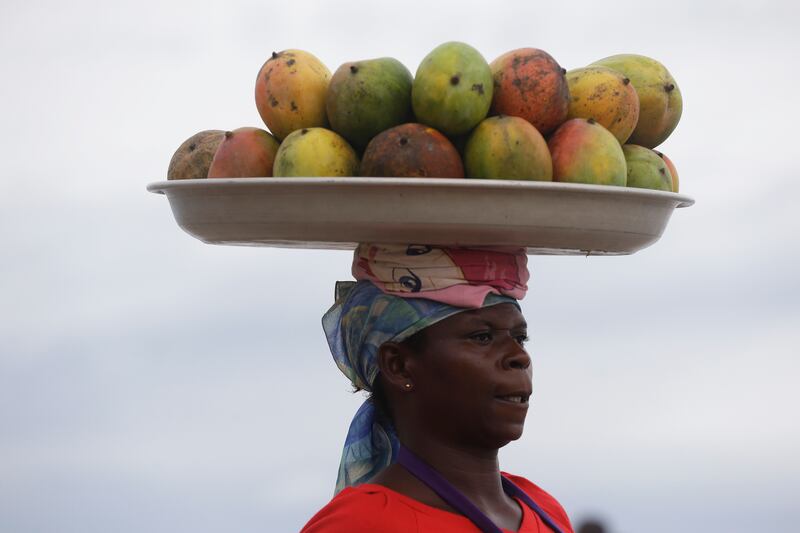 A Ghanaian woman sells mangoes on the beach in Accra, Ghana, on June 7, 2015.