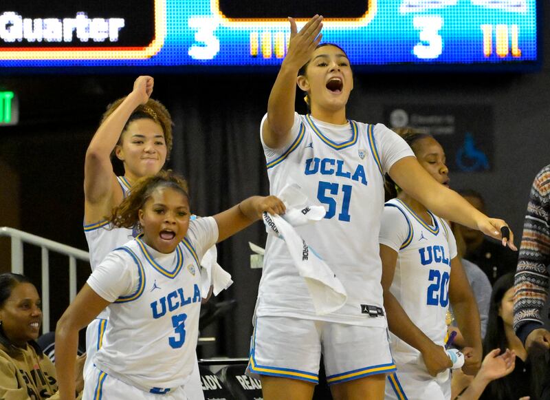 UCLA guard Londynn Jones (3), guard Kiki Rice, center Lauren Betts (51) and guard Charisma Osborne celebrate on the bench during an NCAA college basketball game.