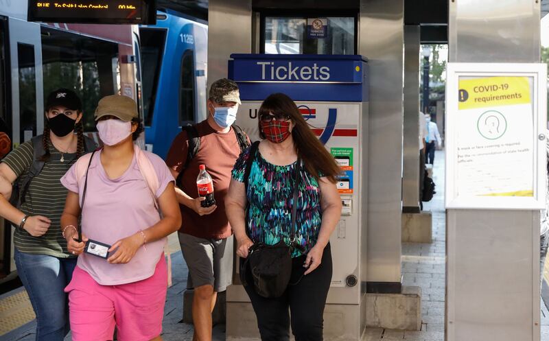 Utah Transit Authority riders wearing masks navigate the TRAX platform at the City Center Station in Salt Lake City.