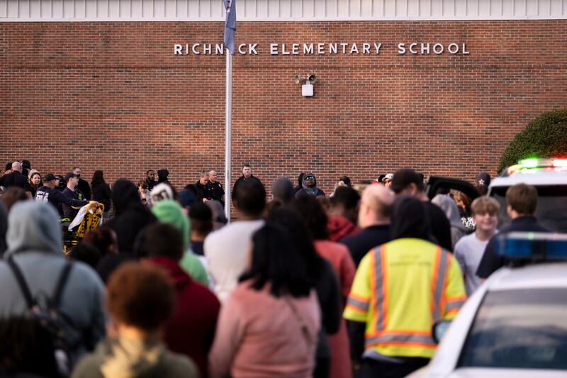 Students and police gather outside of Richneck Elementary School after a shooting, Friday, Jan. 6, 2023 in Newport News, Va. A shooting at a Virginia elementary school sent a teacher to the hospital and ended with “an individual” in custody Friday, police and school officials in the city of Newport News said.