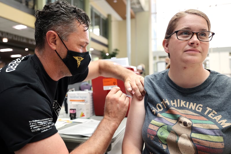 Raymond Searles gives Kristi Rasmussen a COVID-19 vaccination in a clinic at Weber State University.