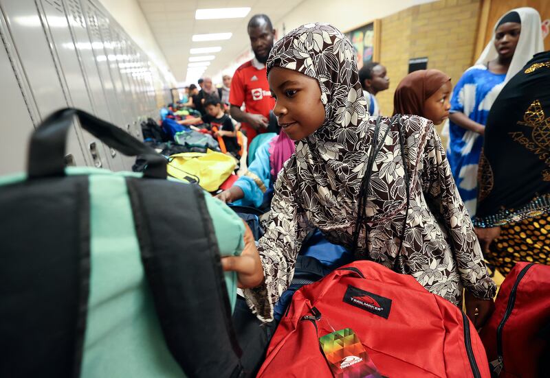 Fatima Musa picks out a backpack for fourth grade during Refugee Back to School Night in South Salt Lake on Aug. 7, 2023.