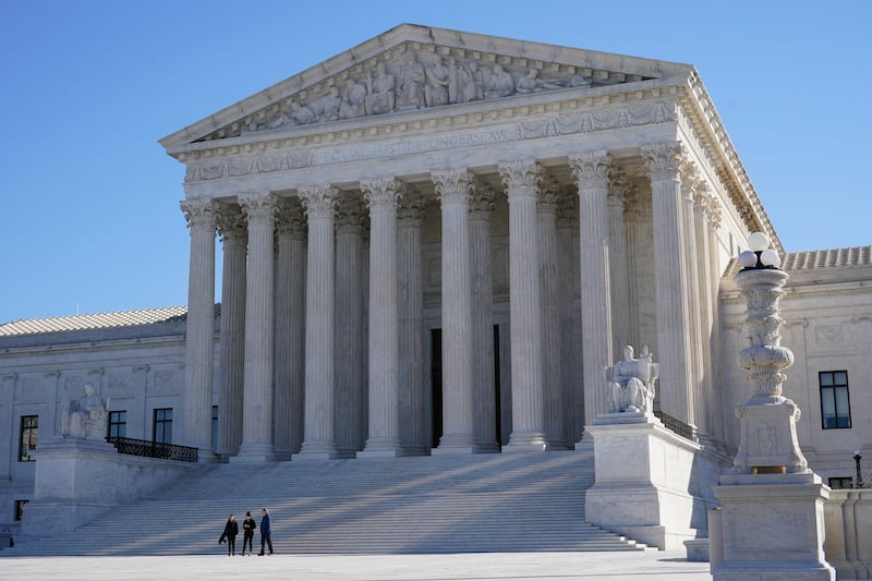 Visitors walk outside the Supreme Court building on Capitol Hill in Washington, on Feb. 21, 2022.