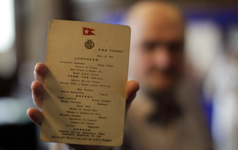 A member of staff from the auction house Aldridge and Son holds an original Titanic menu from April 10, 1912, in 2012.