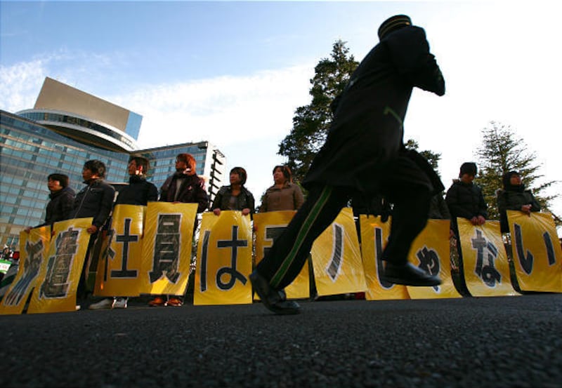 In this Jan. 6 photo, a group of laid-off temporary workers stage a protest outside a hotel where the Japan Business Federation chairman and business circles are holding a new year's party in Tokyo.