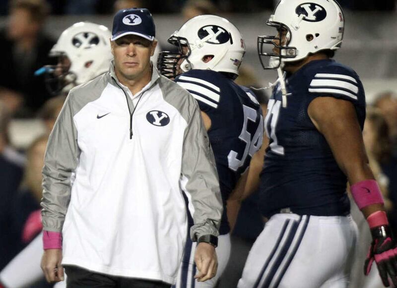 Brigham Young Cougars head coach Bronco Mendenhall walks the field as his players warm up before playing the University of Nevada in a football game at LaVell Edwards Stadium in Provo on Saturday, Oct. 18, 2014.
