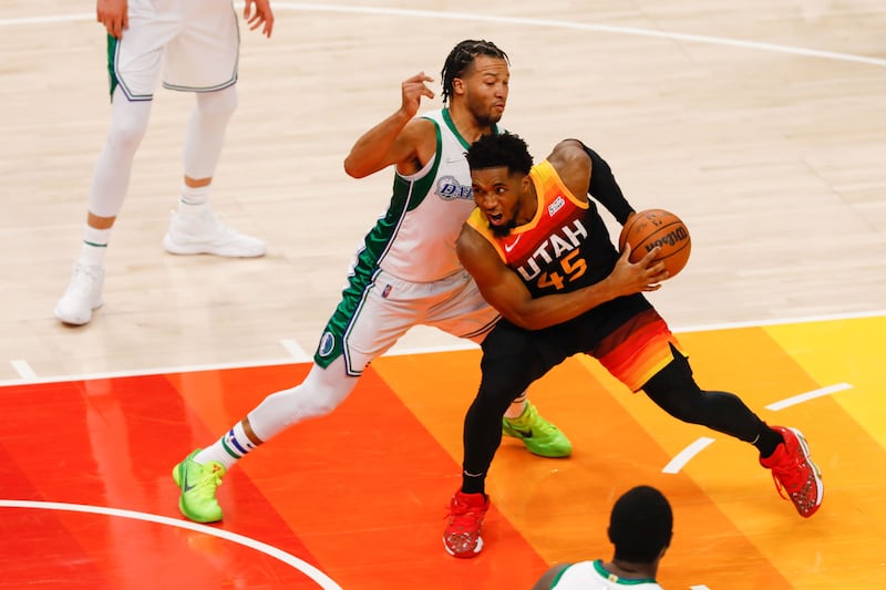 Utah Jazz guard Donovan Mitchell, wearing black, goes past Dallas Mavericks guard Jalen Brunson