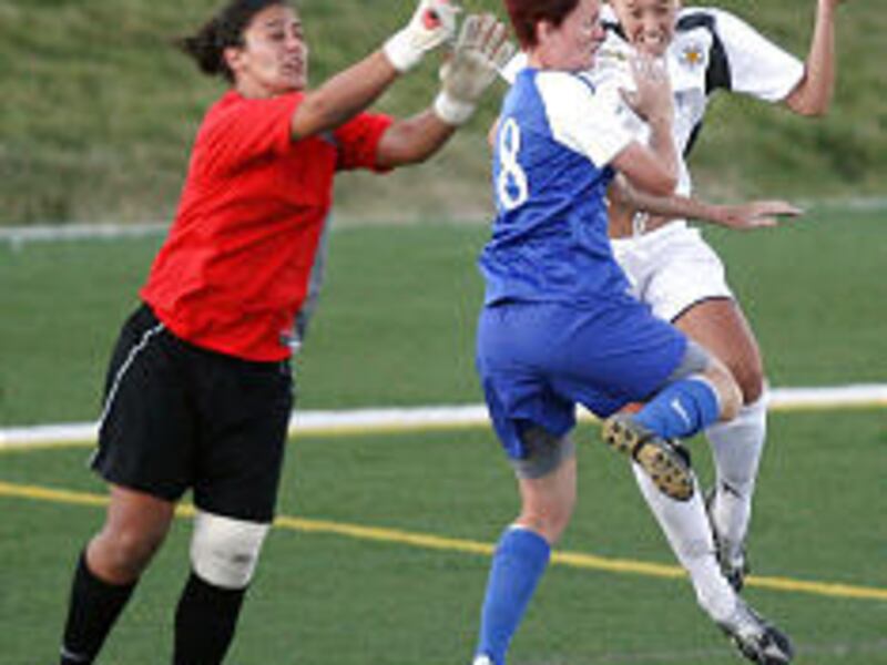 Utah Spiders forward Katie Fellows, right, goes up for a header against Rush Salt Lake City players Becky Hogan (18) and keeper Dimitra Poulos during Tuesday's crosstown matchup in Draper.