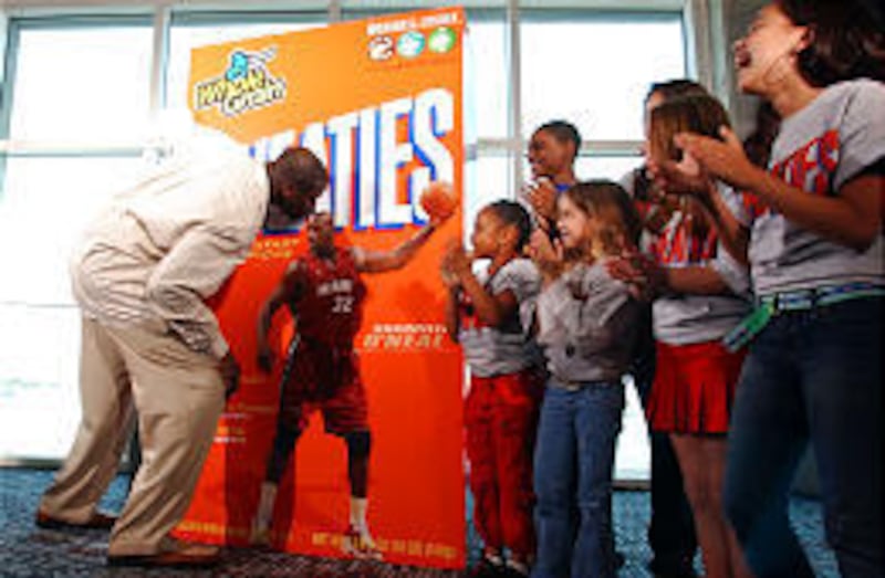 Miami Heat's Shaquille O'Neal kisses the top of his head on a Wheaties cereal box Wednesday in Miami.