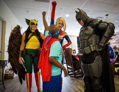 Julian Mitchell, 6, center, poses with superheros during the Superhero Training Academy charity event hosted by the Rainy Days Foundation at the Ronald McDonald House in Salt Lake City on Sunday, Oct. 28, 2018.