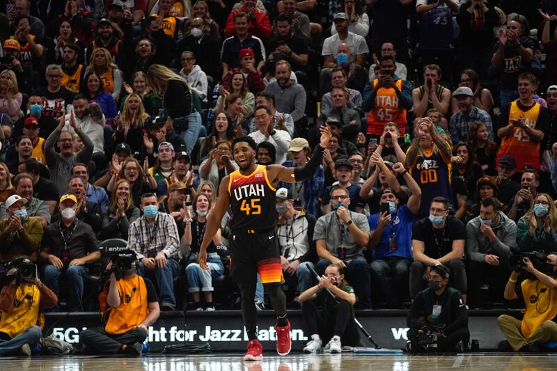Utah Jazz guard Donovan Mitchell, wearing black, cheers with the crowd