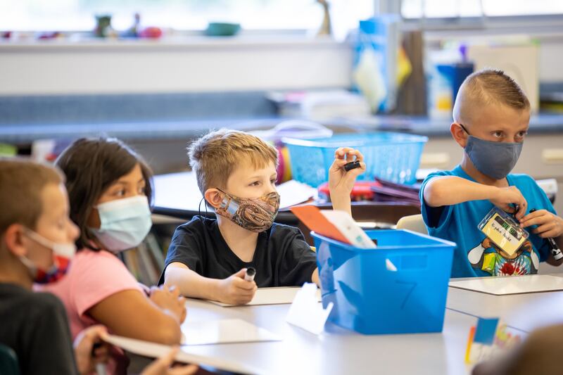 Josh Bird, Leslie Mancilla, Kaiden Smolka and Kingston Pedokie wear masks in their third grade class at Nibley Park School.