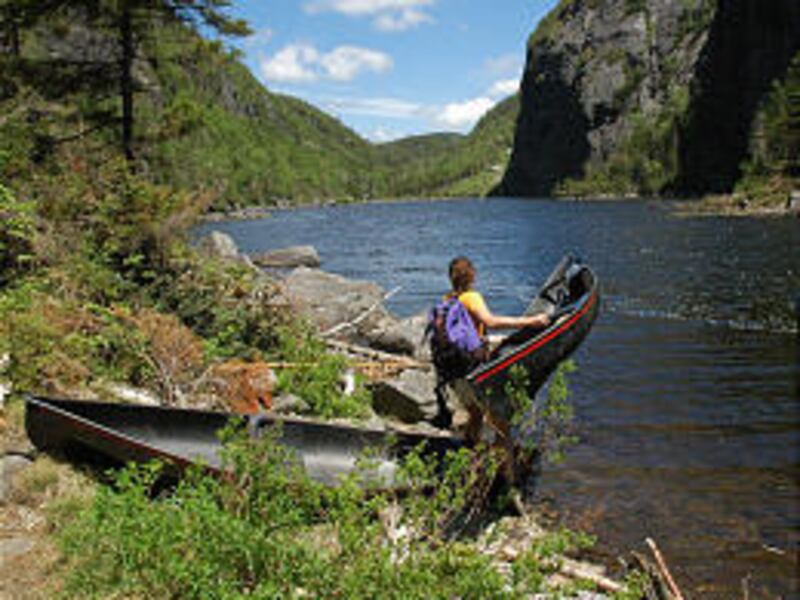 Susan Bibeau of Saranac Lake, N.Y., launches a Hornbeck Black Jack canoe on Avalanche Lake in Keene, N.Y., this summer. At 12 pounds each, the canoes weigh less than a full backpack and are just about a fifth the weight of most canoes.