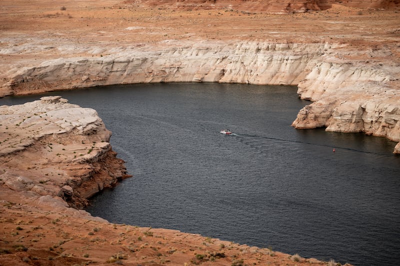 A boat navigates through Lake Powell near Page, Ariz., on Tuesday, July 19, 2022.