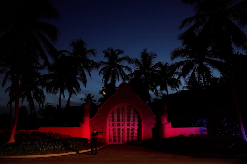 A man stands outside an entrance to former President Donald Trump’s Mar-a-Lago estate, Monday, Aug. 8, 2022, in Palm Beach, Fla.