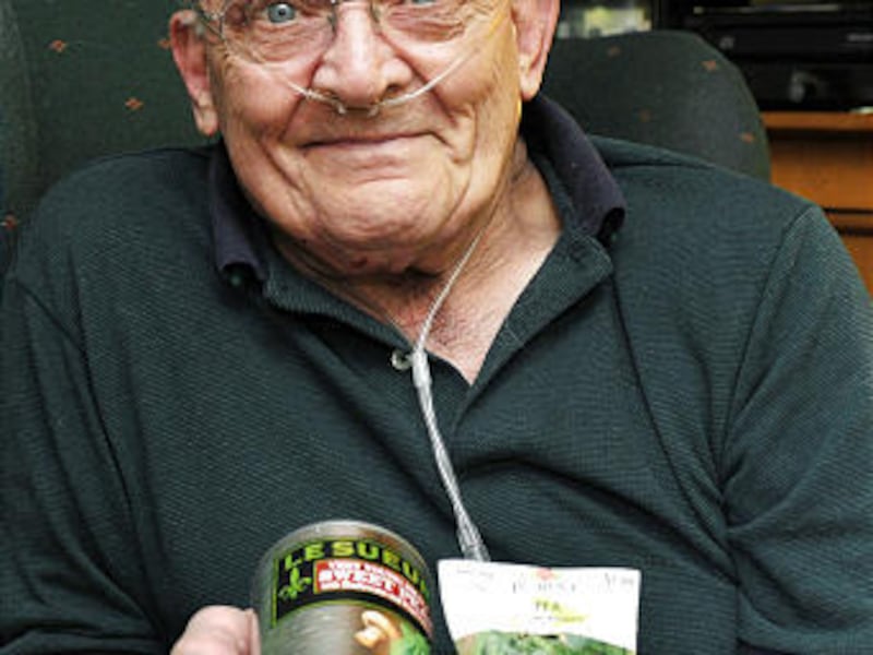 Ron Sveden holds a can of peas and bag of pea seeds that he received from friends after doctors discovered a pea growing in his lung.
