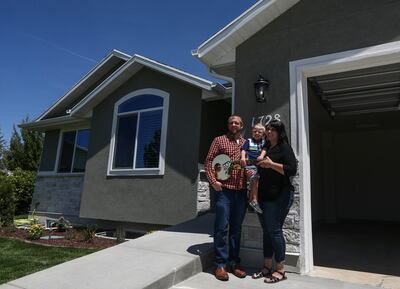Tyler, Angela and Lindon Farrell posing for a photo in front of their new home in Layton on Thursday, July 18, 2019. Lindon, 4, was diagnosed with acute kidney failure at 3 months old, prompting the family to sell their house in order to pay for medical e